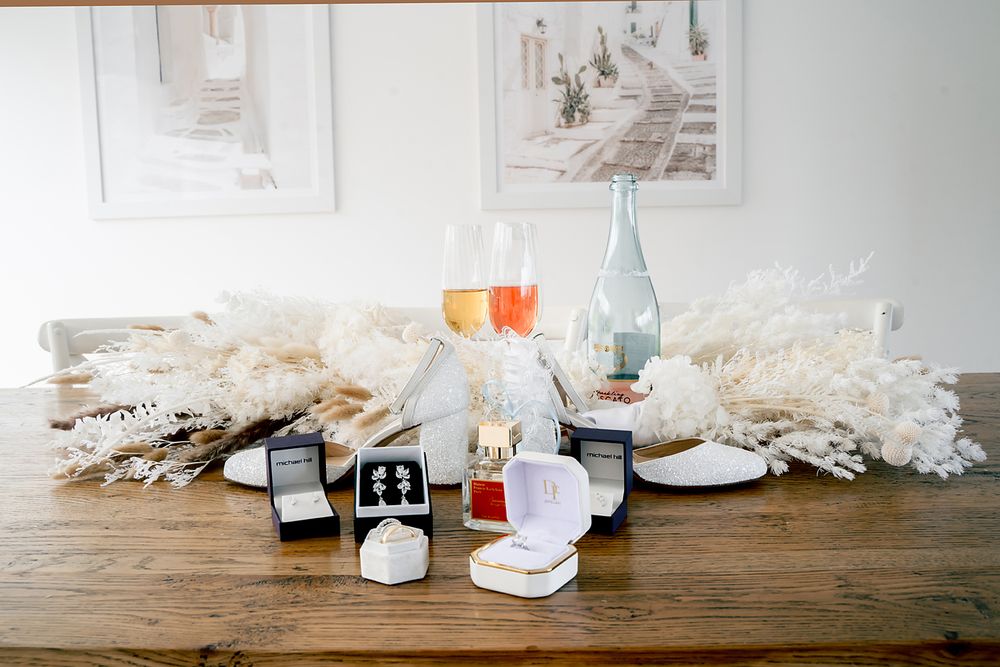White ceramic tableware and glass bottles arranged artistically on a rustic wooden surface against a light background.