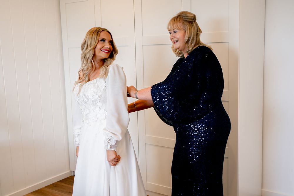 A series of photos showing someone in a navy dress making adjustments to a person wearing a white lace dress.