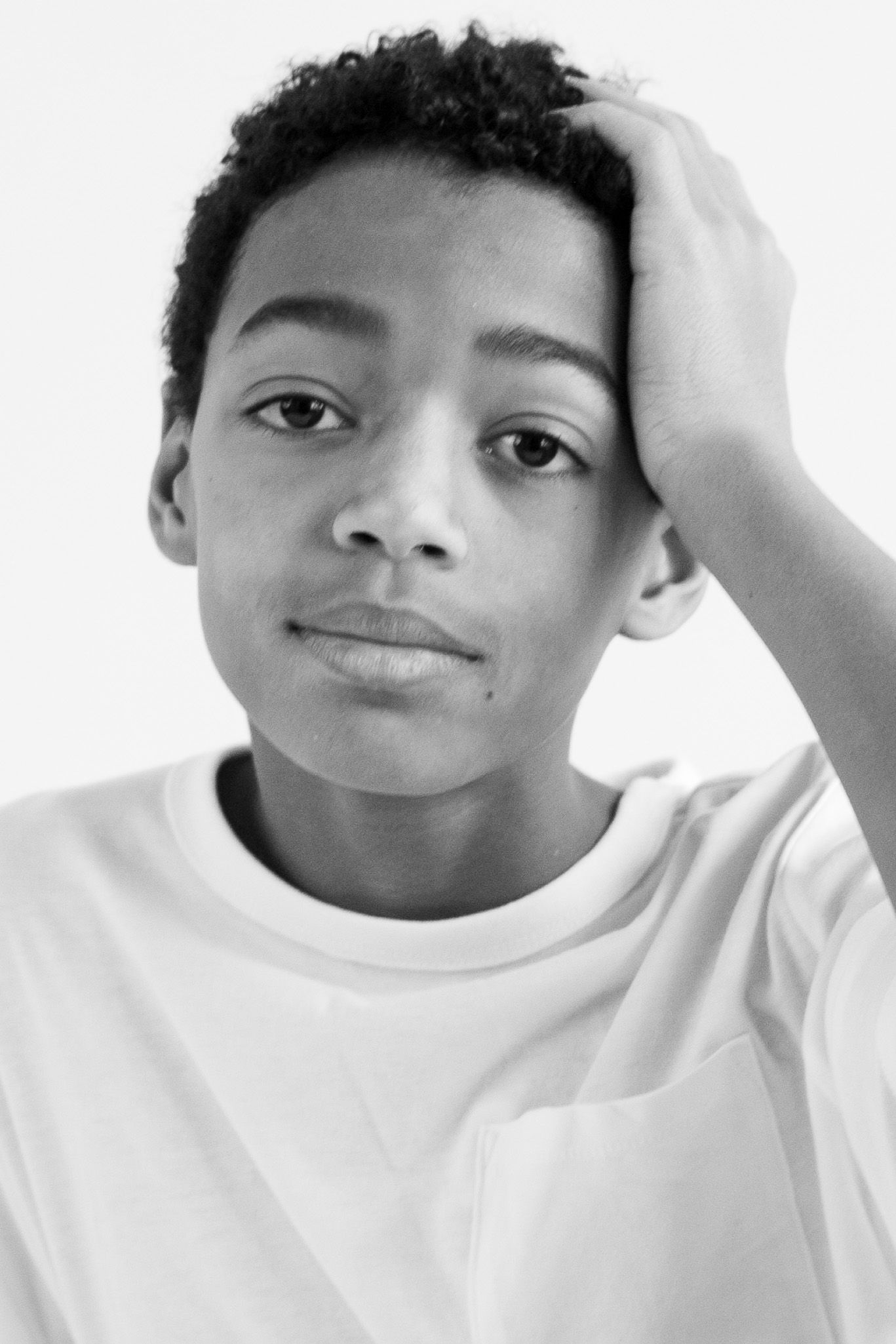 A series of four black and white portraits showing playful expressions against a white background.