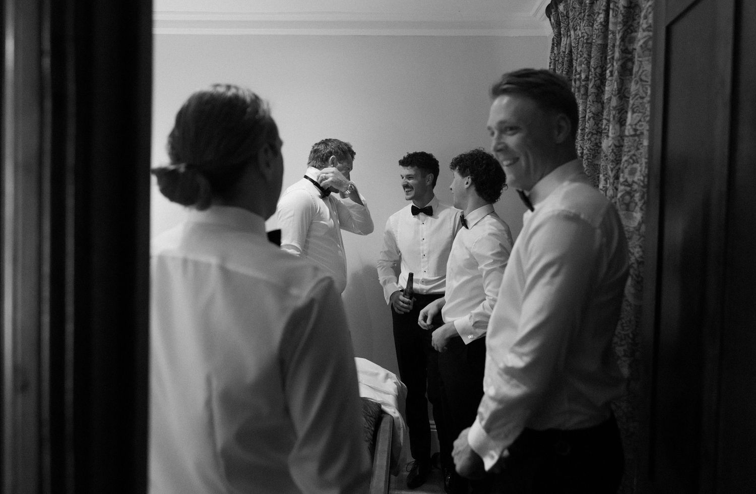 A black and white panoramic photograph shows people gathered in formal attire at what appears to be a social event.