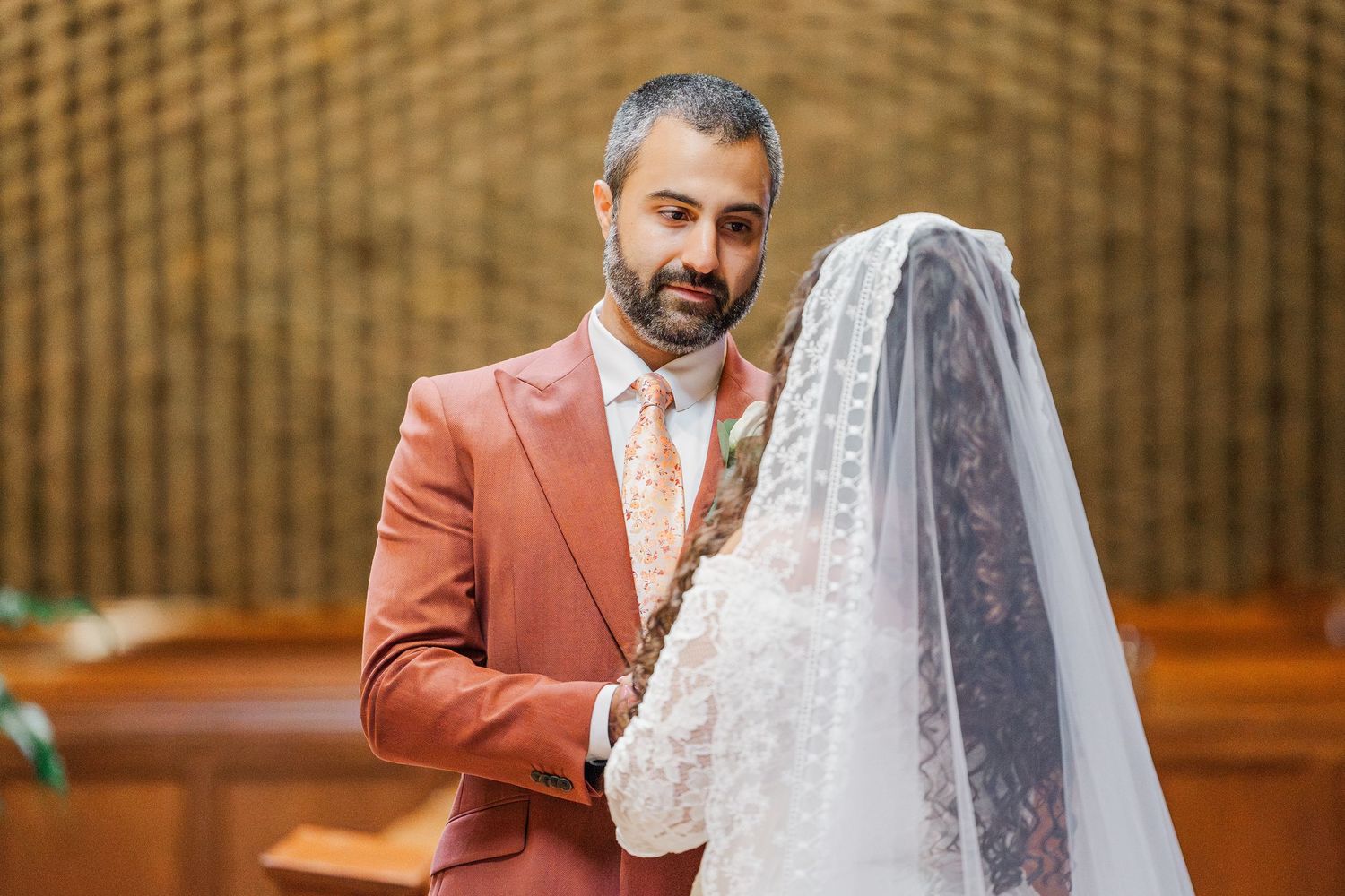 A couple in formal wedding attire shares a tender moment during their celebration at an elegant venue.