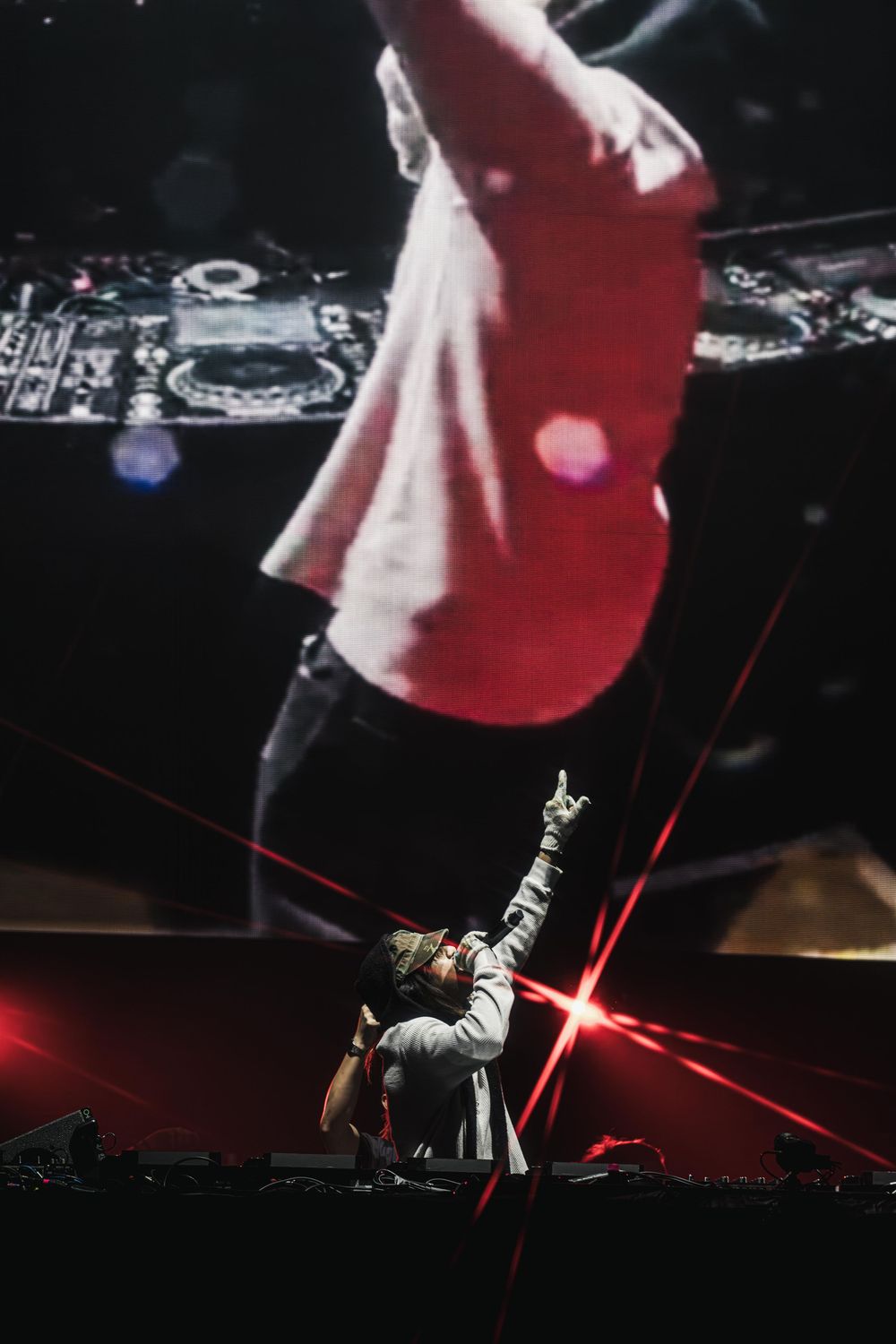 Concert stage performance with dramatic red lighting and smoke effects creating a dynamic atmosphere.