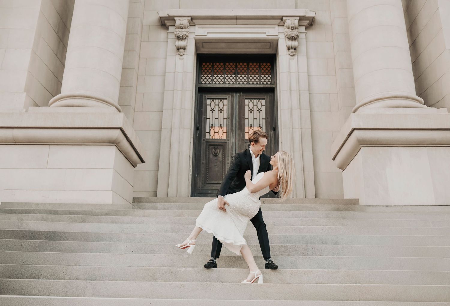 Romantic engagement photo of couple in downtown Dallas with groom dipping bride in city street