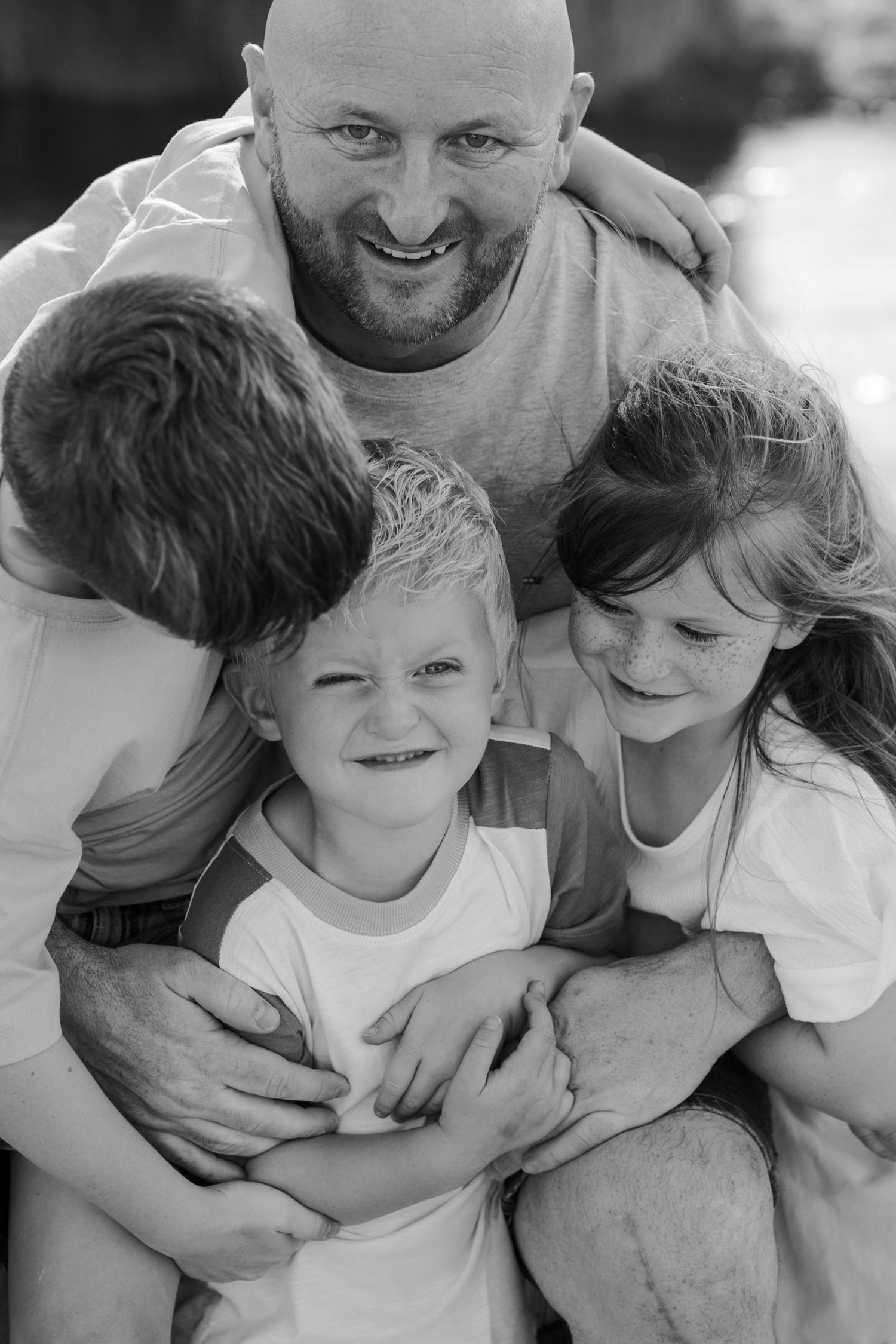 A black and white photo series shows a family sharing joyful moments and embraces together.