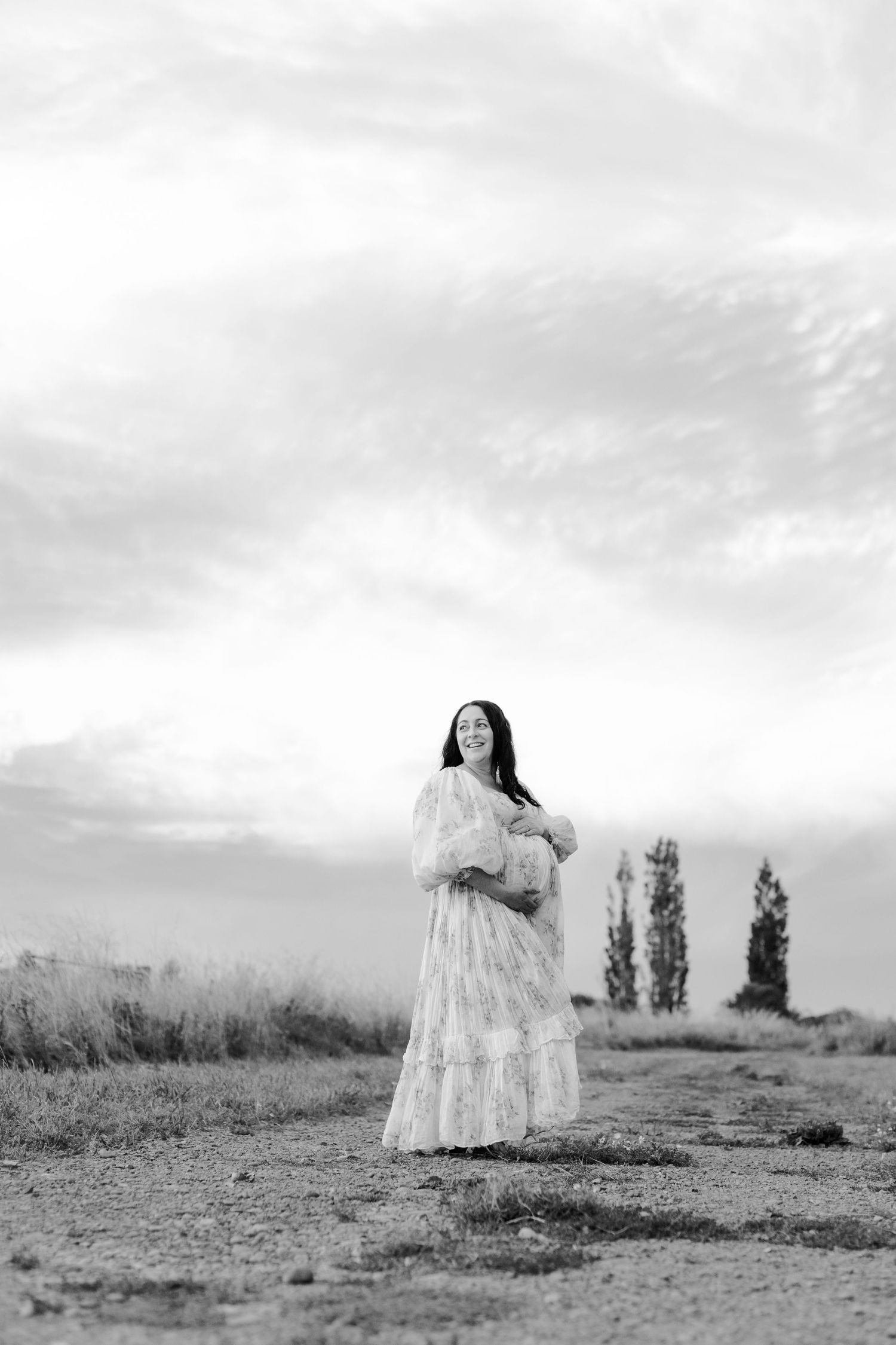 A sequence of black and white photos showing a figure in a white dress walking away across a barren landscape.