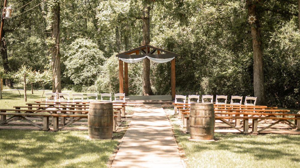 Three scenic garden walkways lined with white chairs creating an enchanting outdoor setting for a special event.