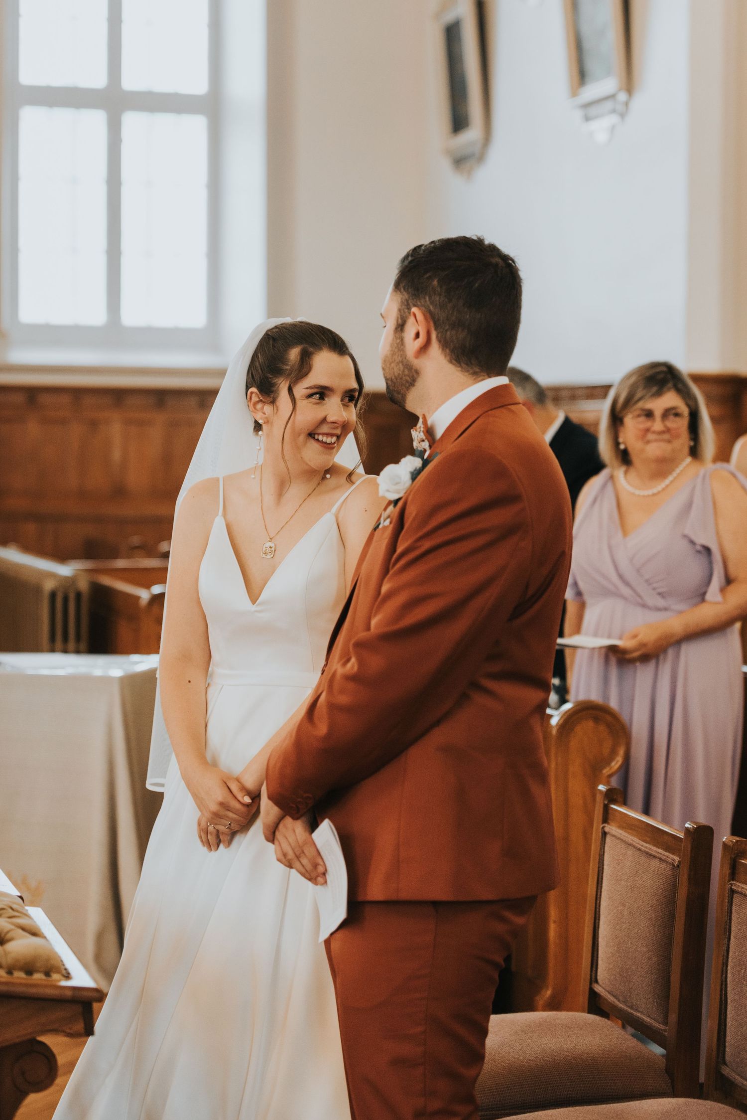 A joyful wedding ceremony moment captured in a church with warm lighting and rustic wooden details.