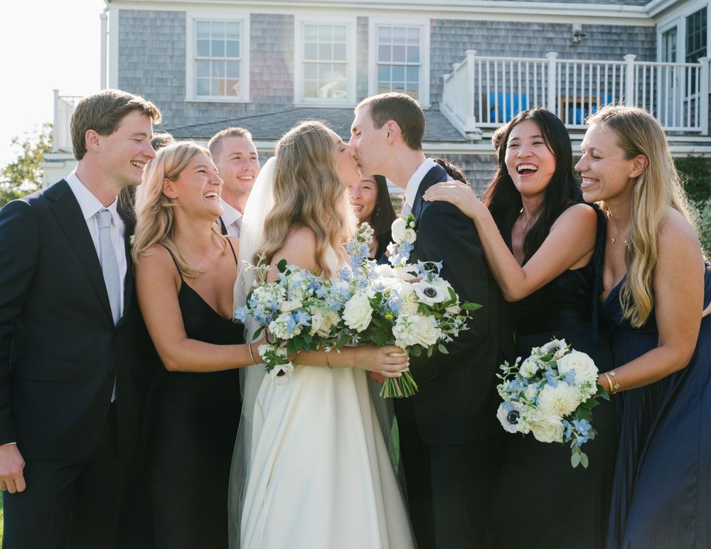 Group shot of the entire wedding party, from bride and groom to family and friends, celebrating together
