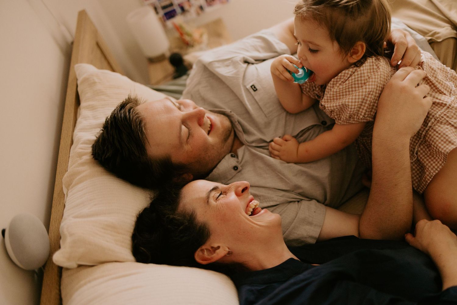 A candid moment of joyful laughter and connection while relaxing together on a bed.