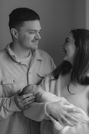 A couple in black and white sharing an intimate moment while embracing and smiling at each other.