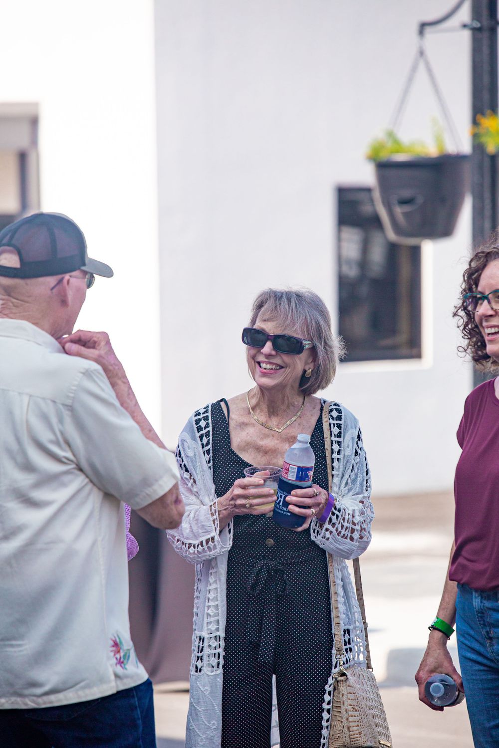 People enjoying drinks and conversation at an outdoor gathering.