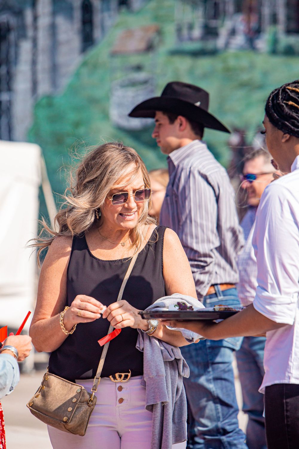 People enjoying a sunny outdoor social gathering with drinks.