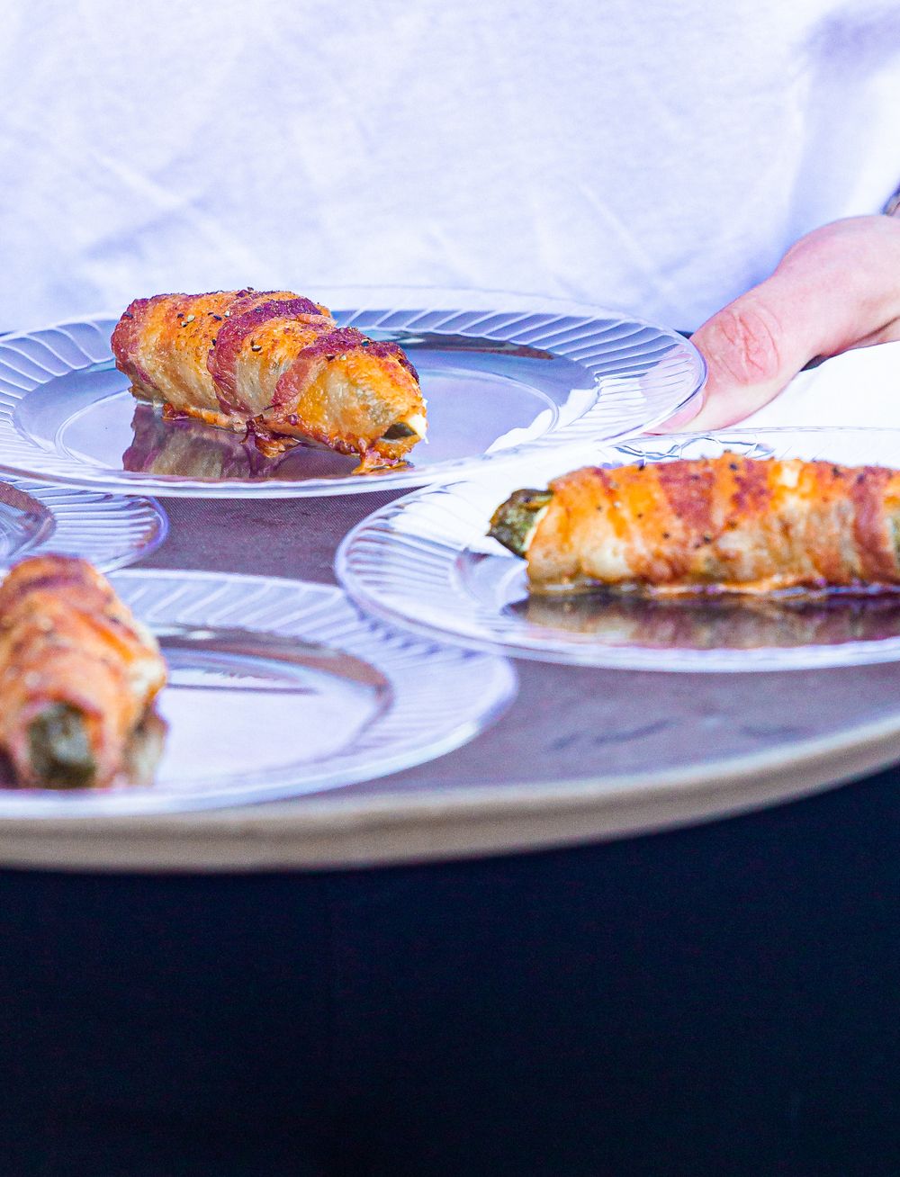 Close-up view of grilled or baked salmon fillets being served on white plates.