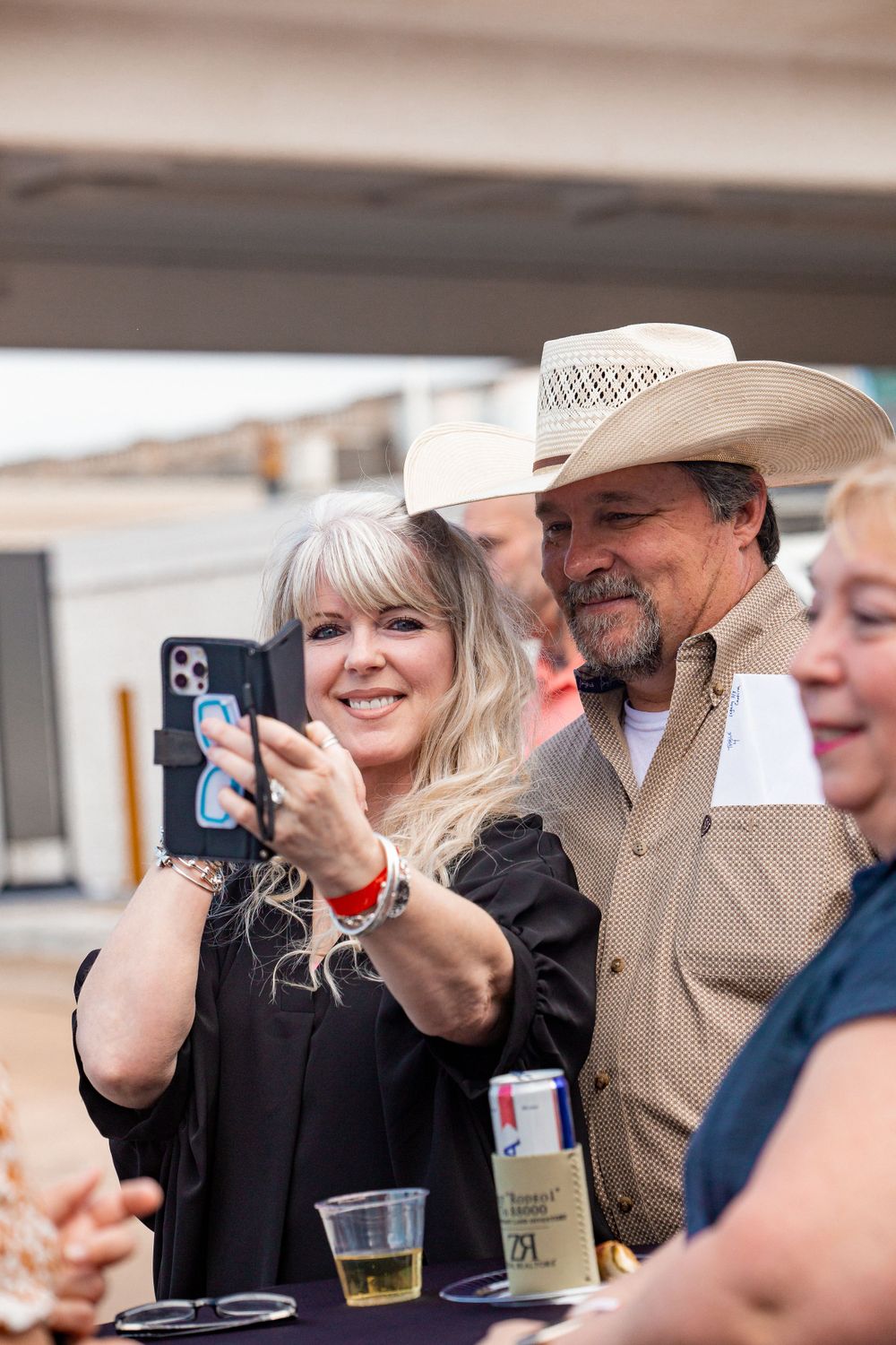 People taking photos with phones at an outdoor social gathering.