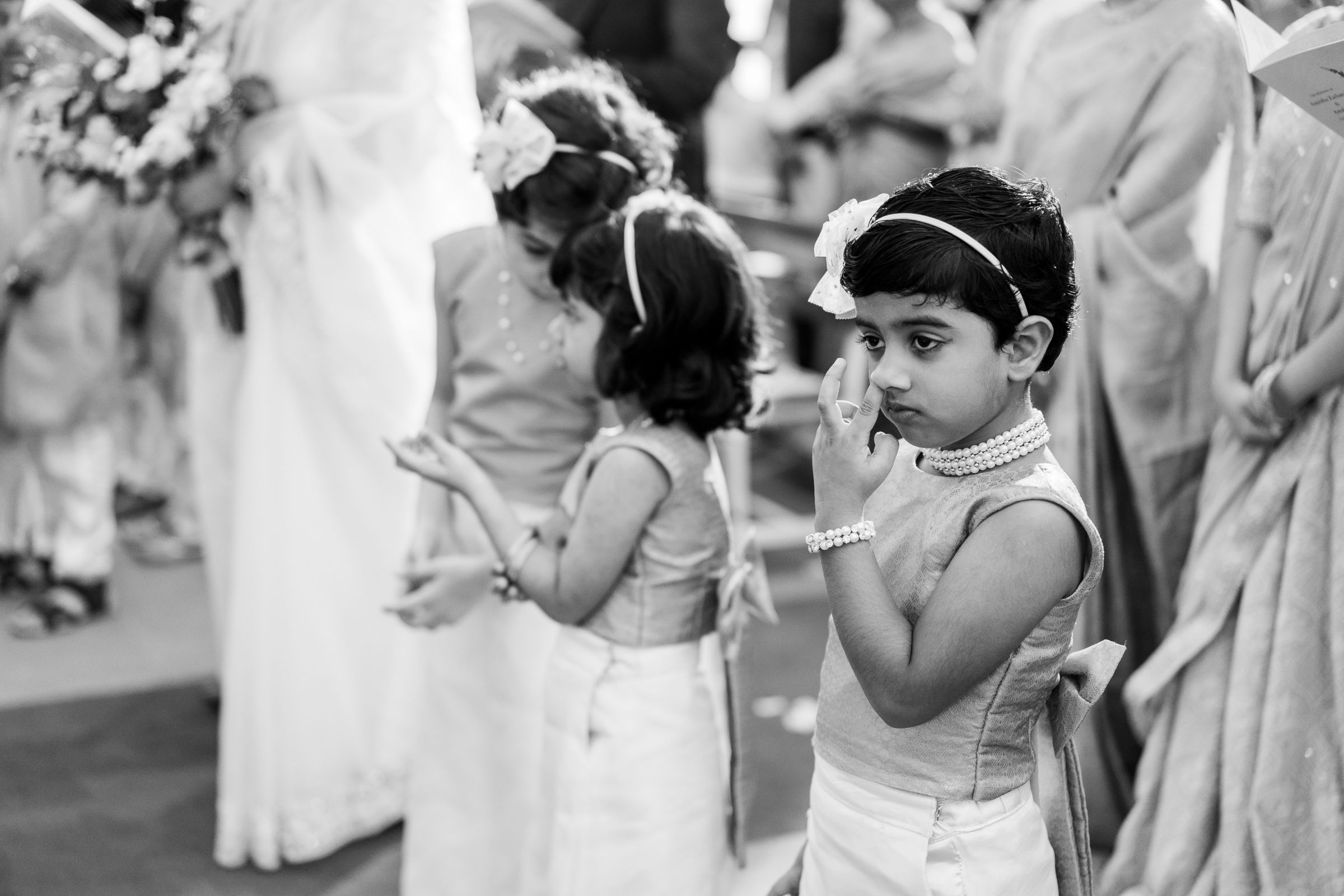 Black and white photograph showing two young children in formal attire at a special event.