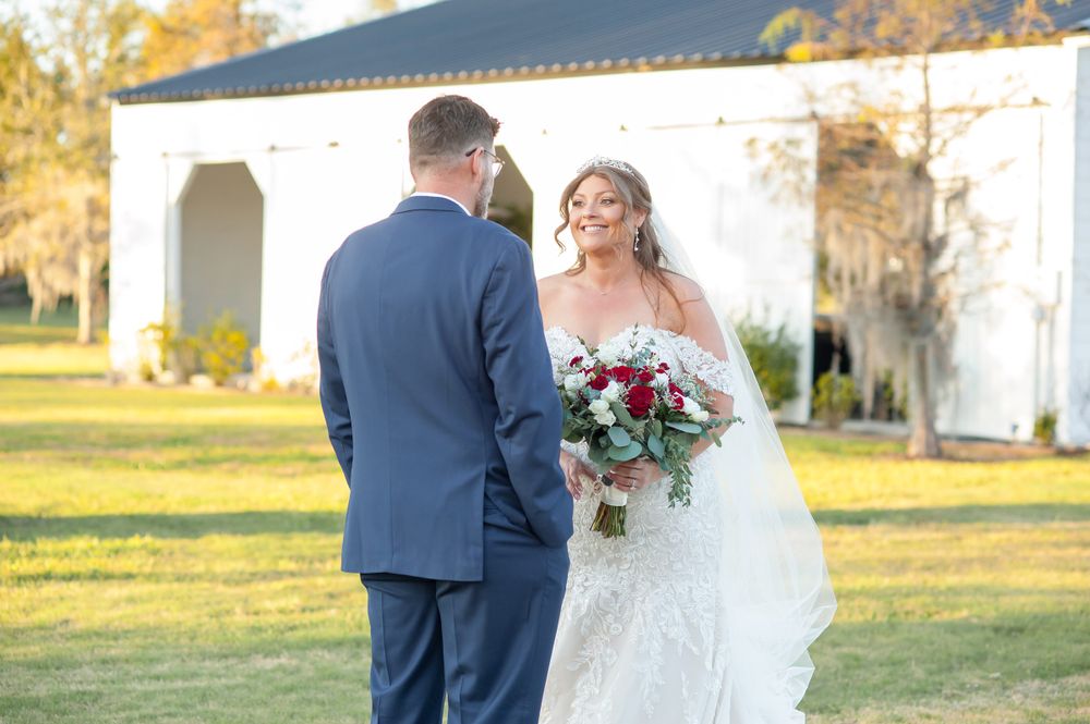 A wedding couple shares an intimate moment in front of a white chapel during golden hour.