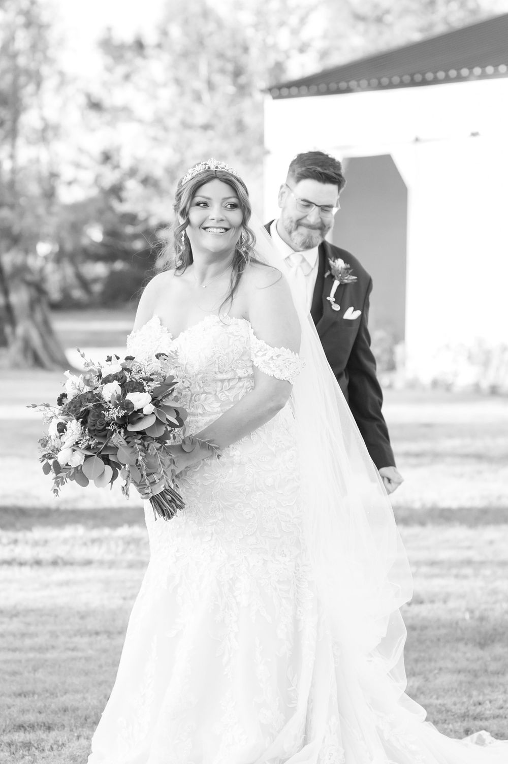 Black and white wedding portrait showing a joyful moment between newlyweds.