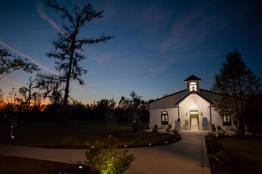 White chapel illuminated at dusk with dramatic night sky.