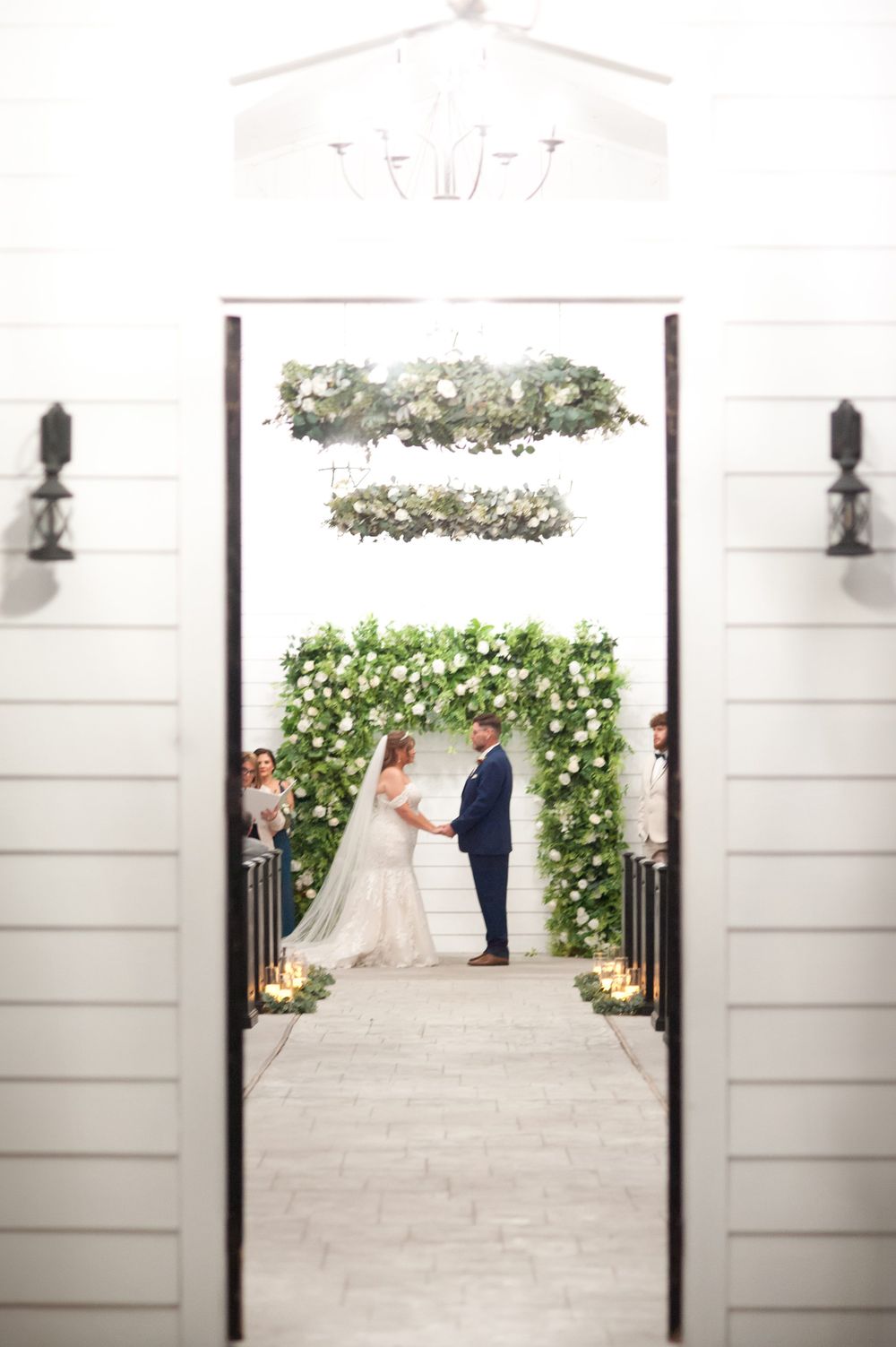 Series of wedding ceremony photos showing progression through white paneled doorways with floral decorations.