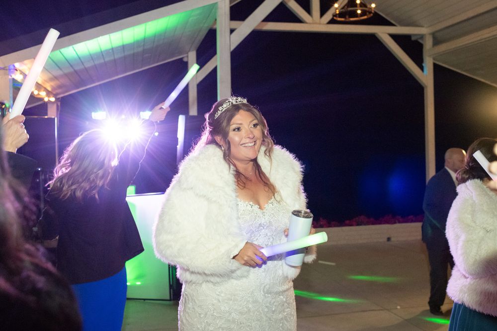 Wedding reception venue lit up at night with sparklers and colored lighting.
