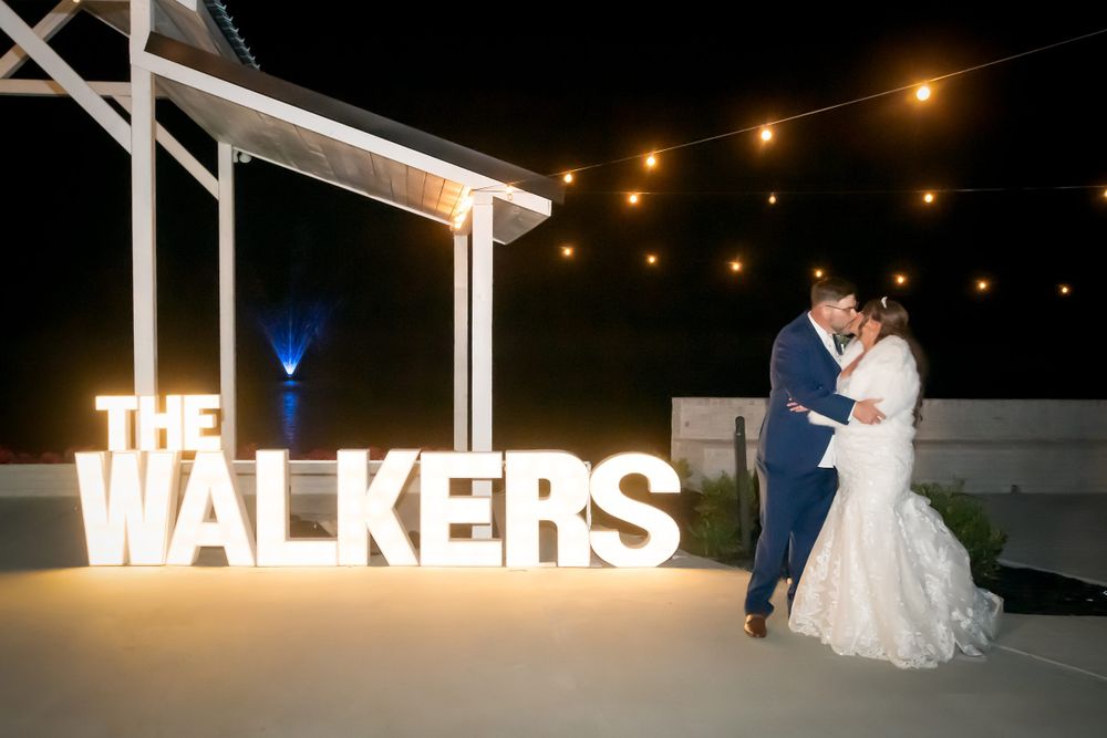 Large illuminated letters spelling 'WALKERS' displayed at nighttime wedding venue.