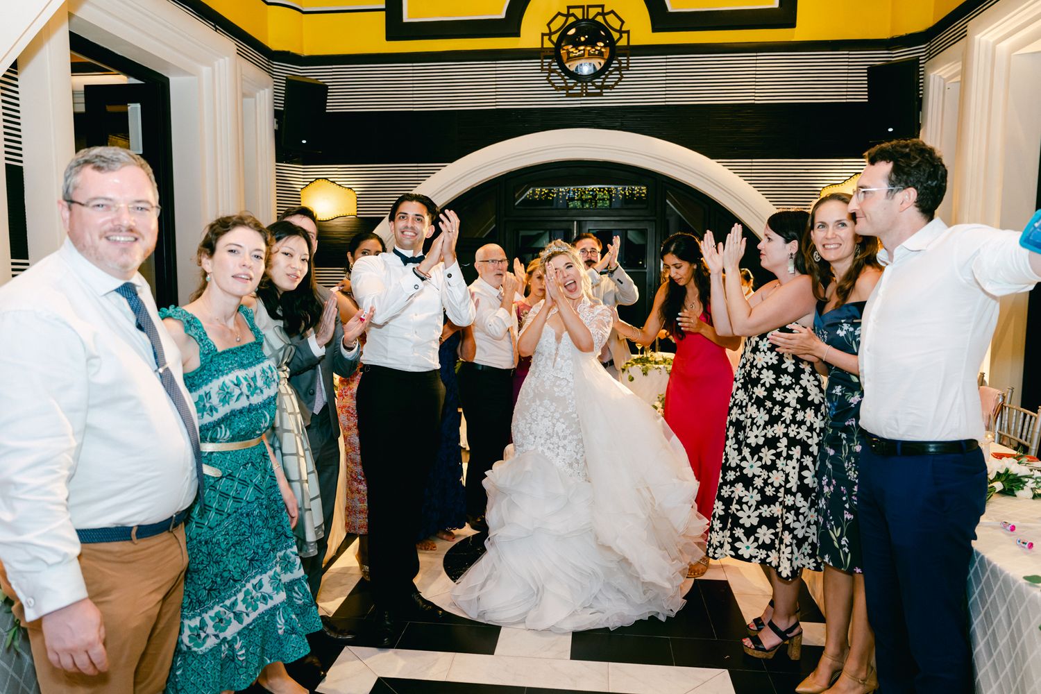 Wedding reception guests dancing and celebrating in a festively decorated venue.