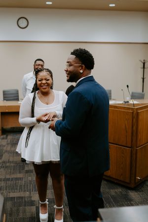 A joyful moment captured in an indoor setting with carpeted floors and wooden furnishings.