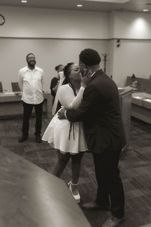 A couple dances together in a carpeted indoor space.