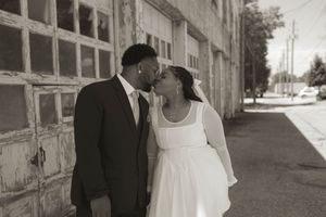 A couple shares an intimate moment in an urban setting.