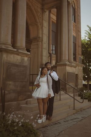 A family photoshoot sequence captured along the exterior of a grand stone building.