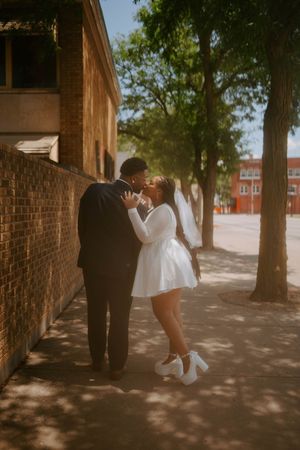 A romantic photoshoot sequence showing a couple dancing and embracing against a brick wall backdrop.