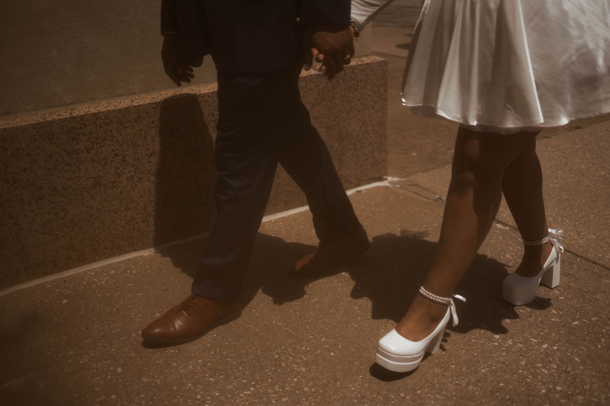 Low-angle shot focusing on wedding shoes and formal attire.