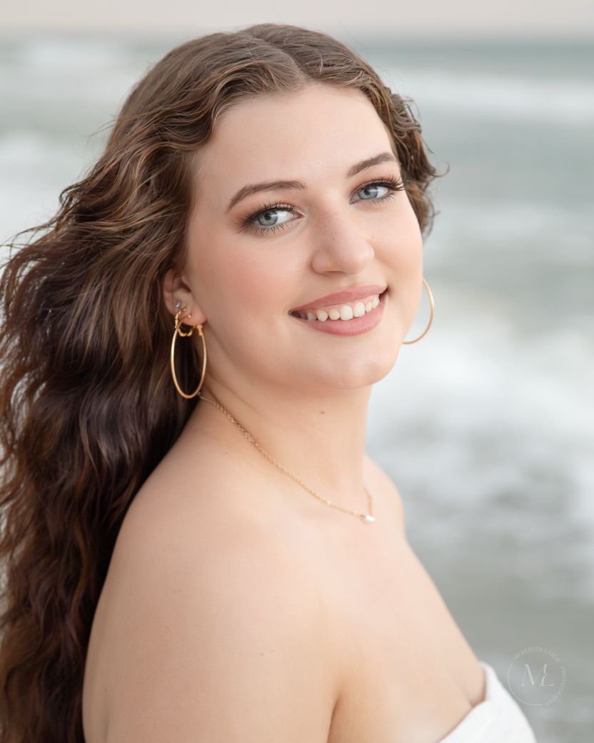 Soft ethereal portrait against an ocean backdrop features gentle lighting and natural styling.
