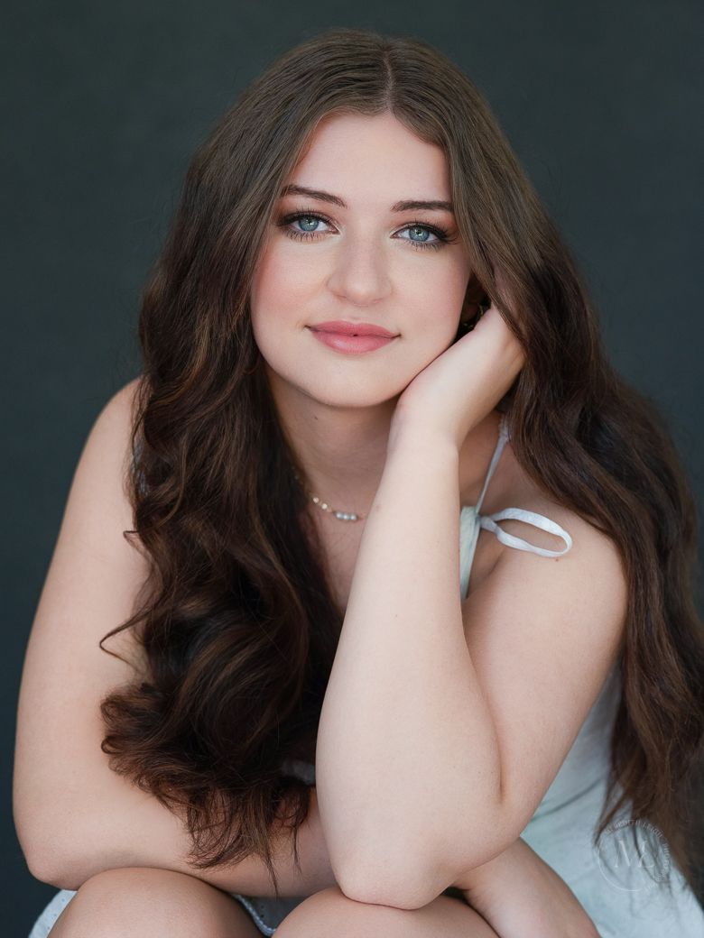 Portrait series showing woman with dark hair in light blue top against dark background.