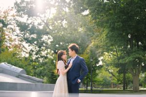 Romantic couple embracing during golden hour in a sunlit garden setting.