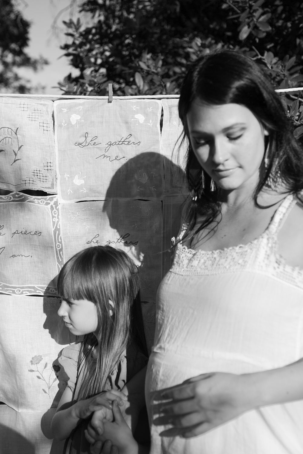 Intimate black and white portrait sequence showing tender familial moments against a white backdrop.