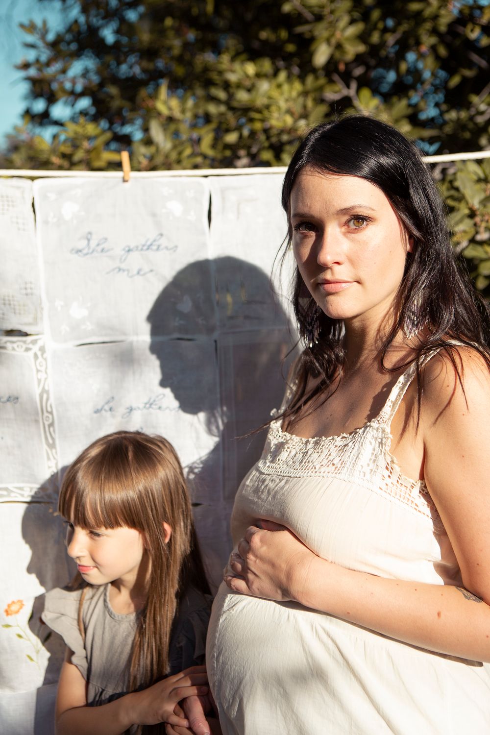 Sun-dappled outdoor portrait series featuring white summer dresses and natural lighting.