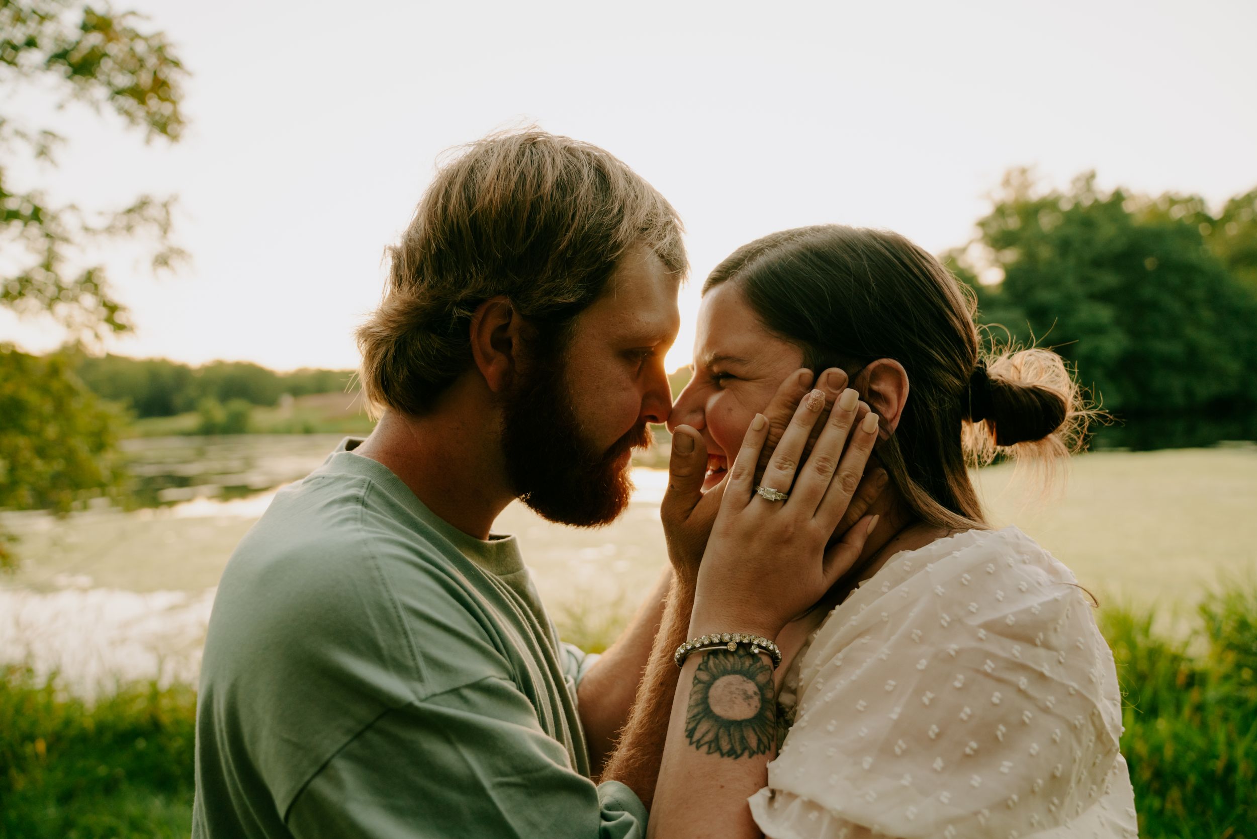 An intimate moment between a couple sharing a tender kiss at sunset.