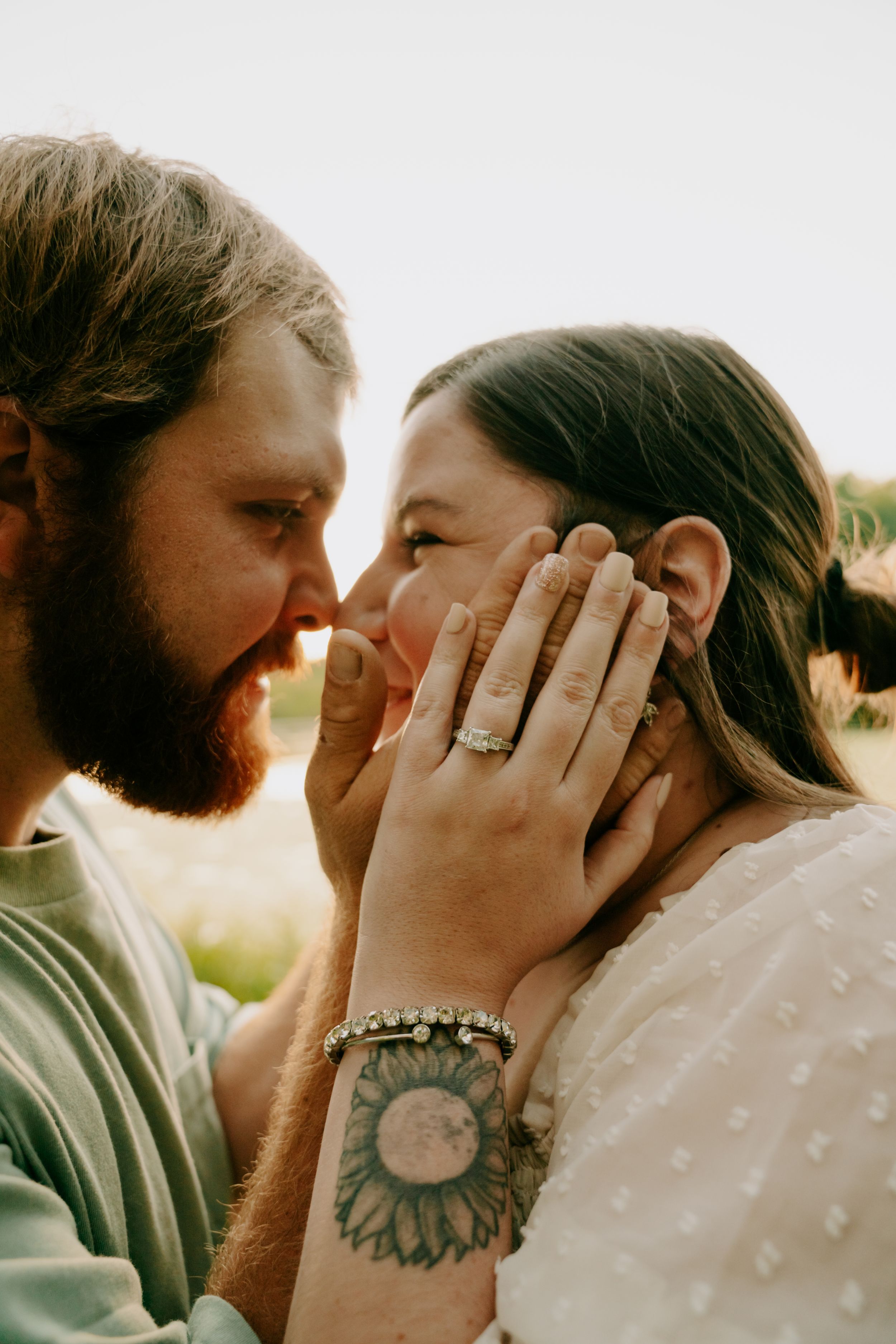 A close-up shot of a couple sharing an intimate moment in golden sunlight.