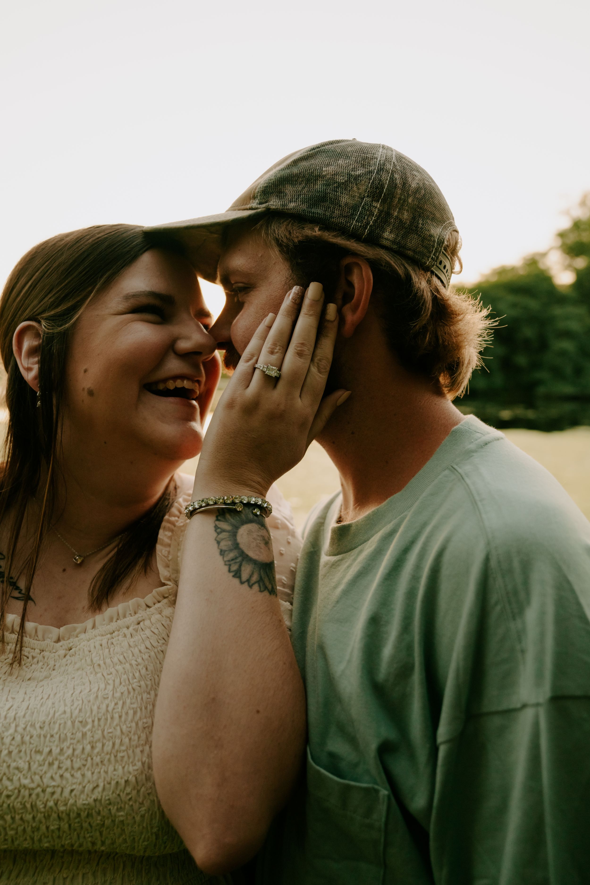 A joyful couple sharing laughter during a sunset photoshoot.