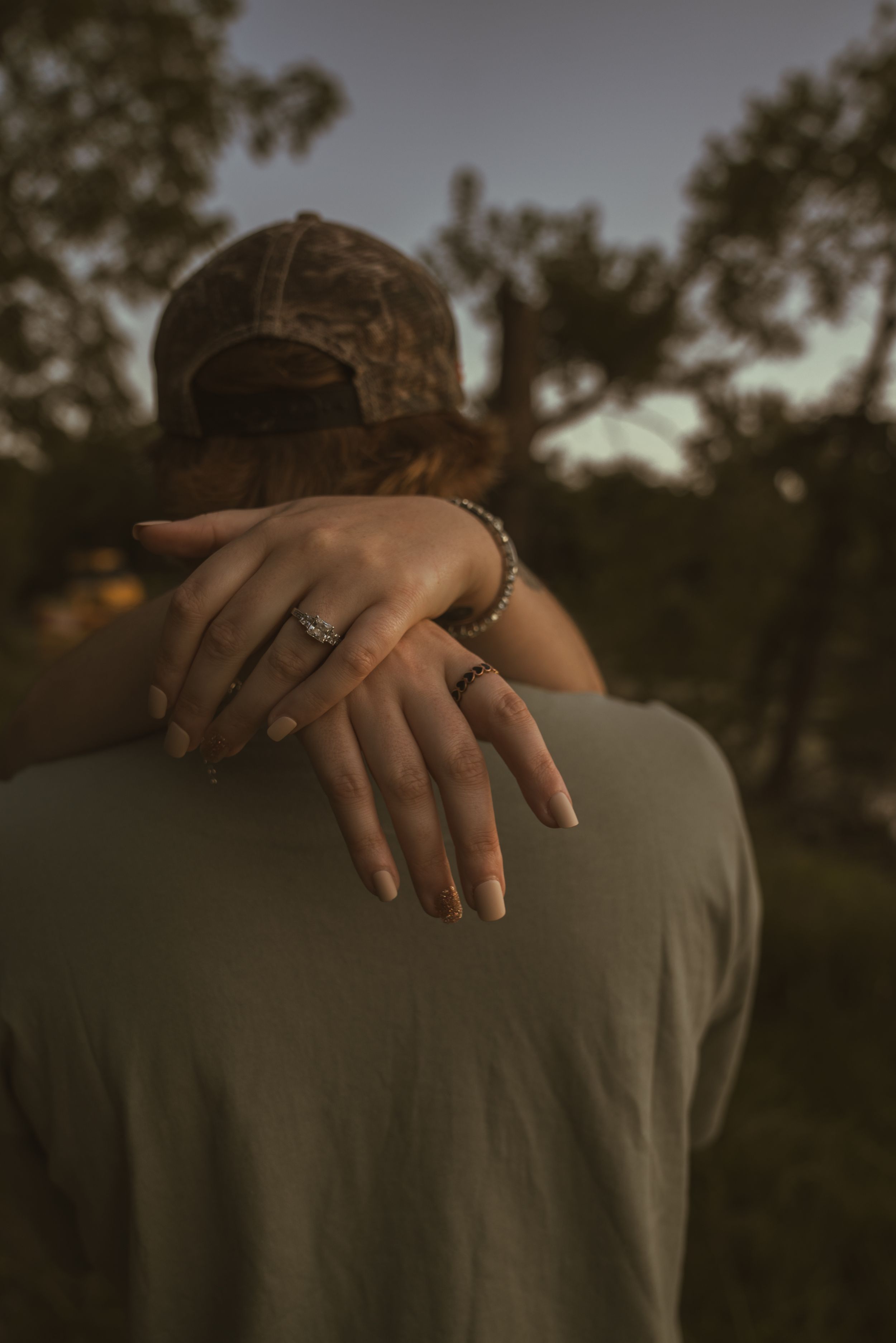 Close-up shots of hands embracing against a dark outdoor background at sunset.