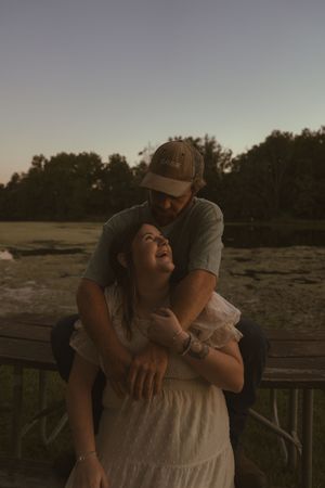 A loving embrace captured during sunset on a rustic wooden deck.