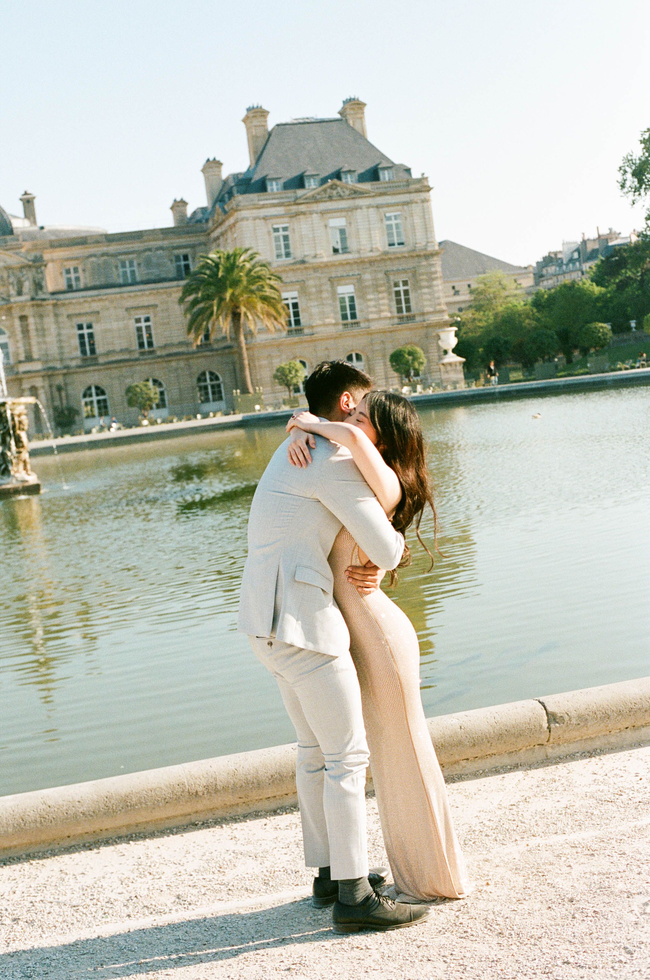 A couple shares a romantic embrace beside the iconic Luxembourg Palace and gardens in Paris, France. Film photoshoot Paris.