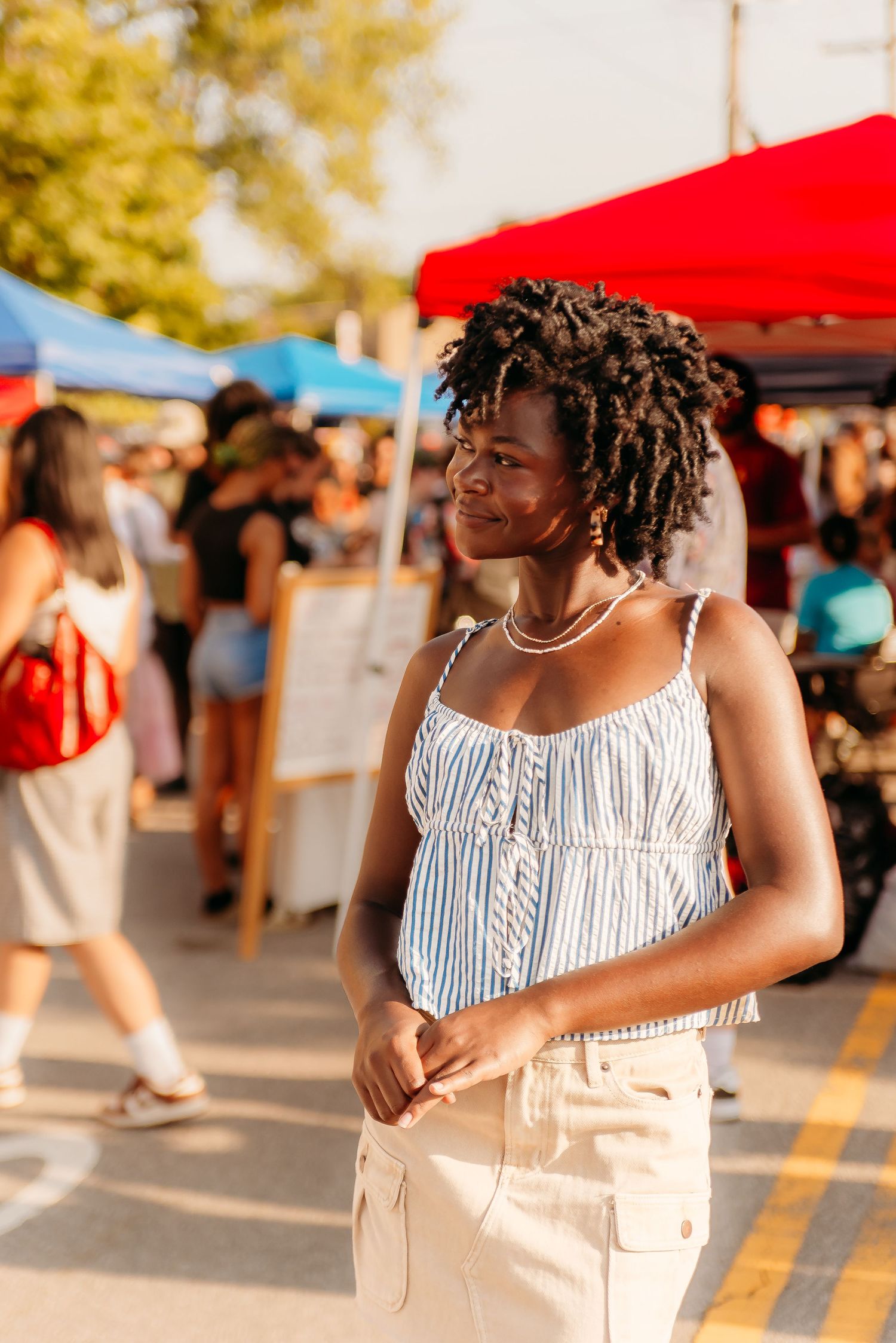 Sequence of candid moments showing person in striped top and light pants enjoying a sunny outdoor market setting.