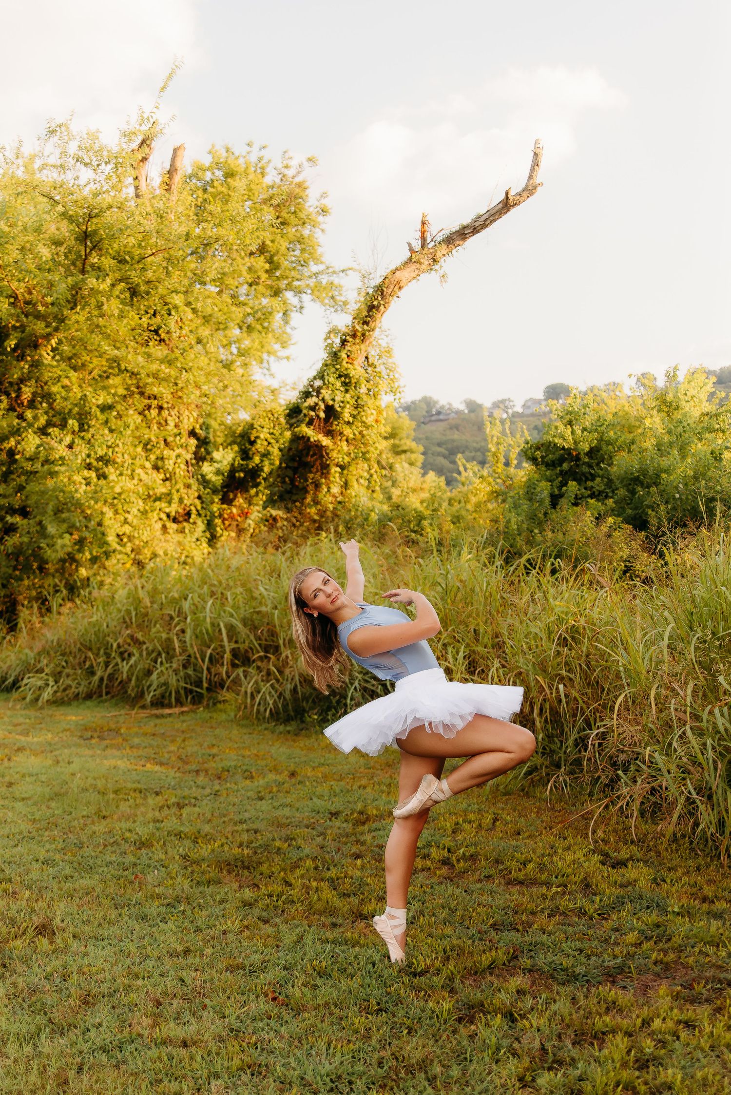 A dancer performs a dynamic twirling motion in a grassy field at sunset in a series of connected photos.