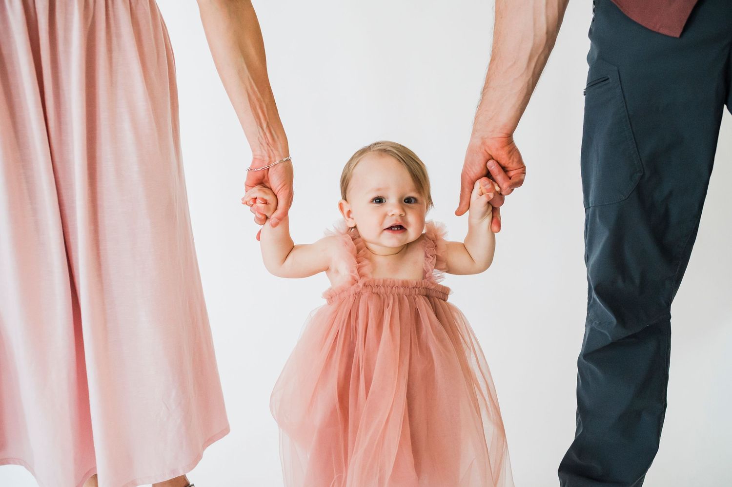A collage of cropped images showing small feet in pink dresses and formal wear at a special occasion.