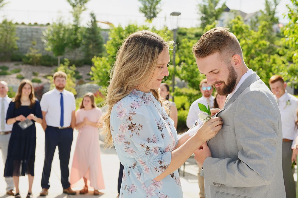 Idaho Falls wedding photographer ShutterGirl   candid photo of mom pinning flower on groom at Pocatello Idaho temple