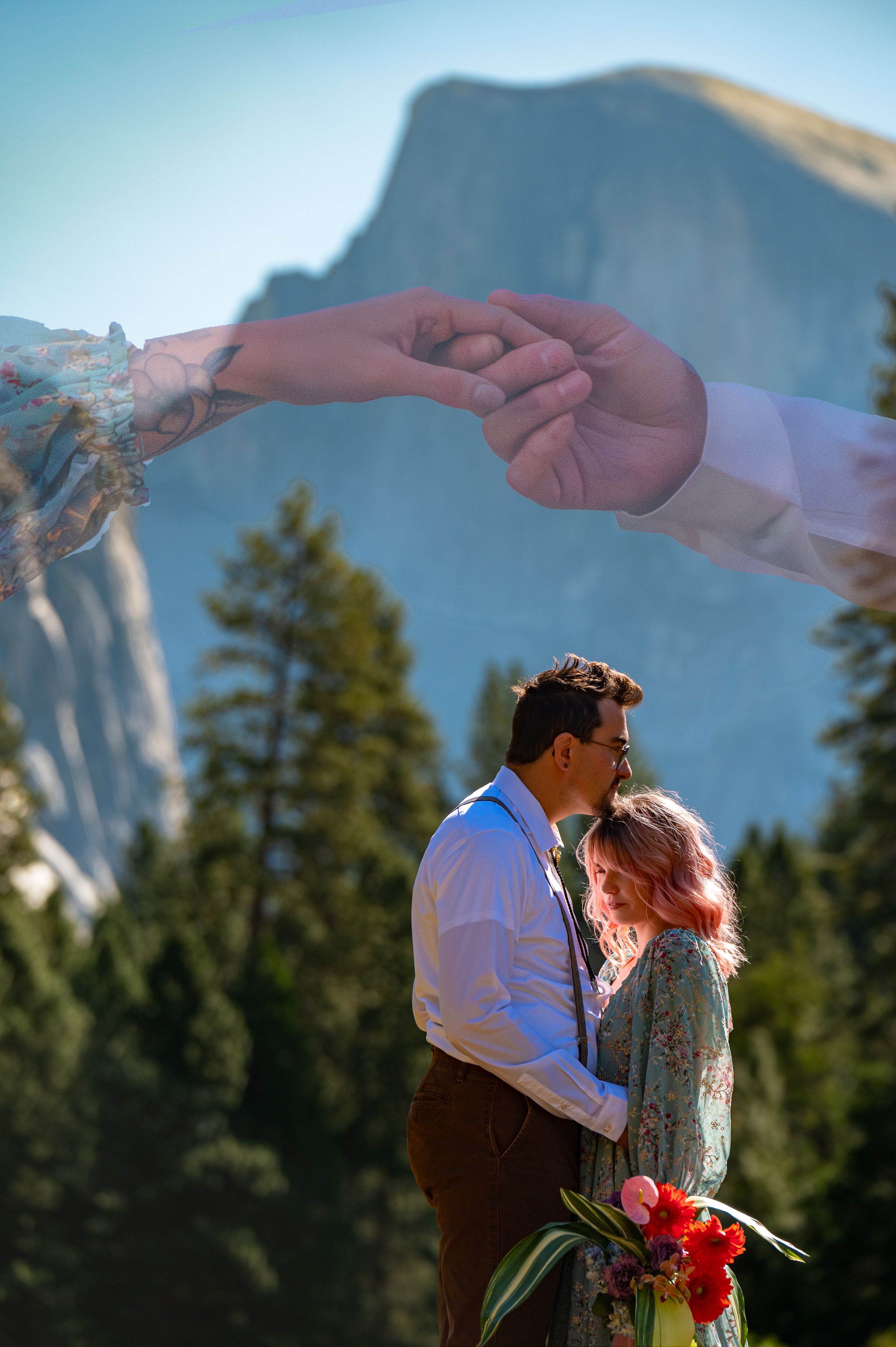 Intimate couple holding hands against the backdrop of Half Dome in Yosemite National Park.