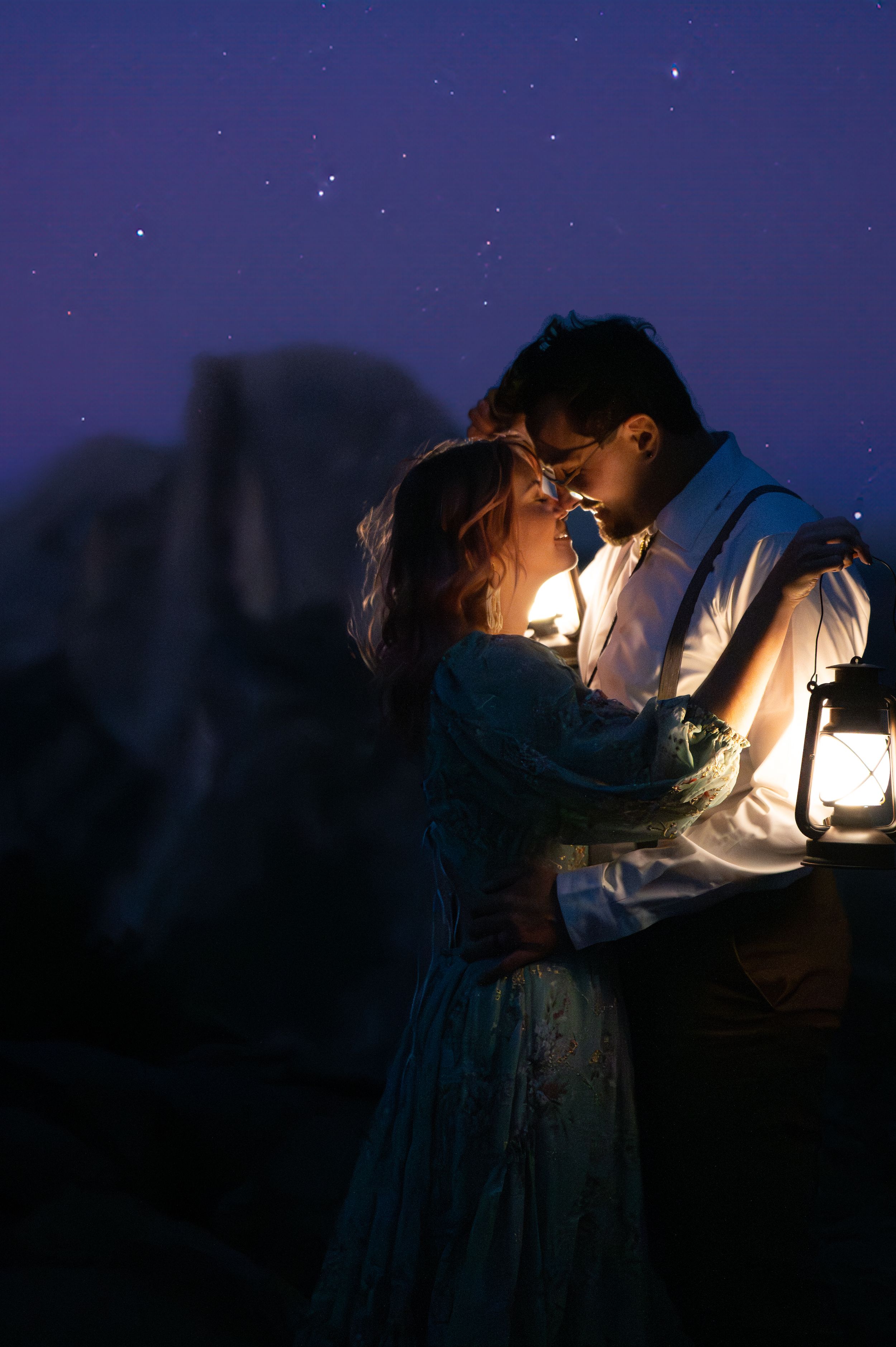 A magical nighttime moment captured with lantern light against a starry backdrop in vintage-style clothing.