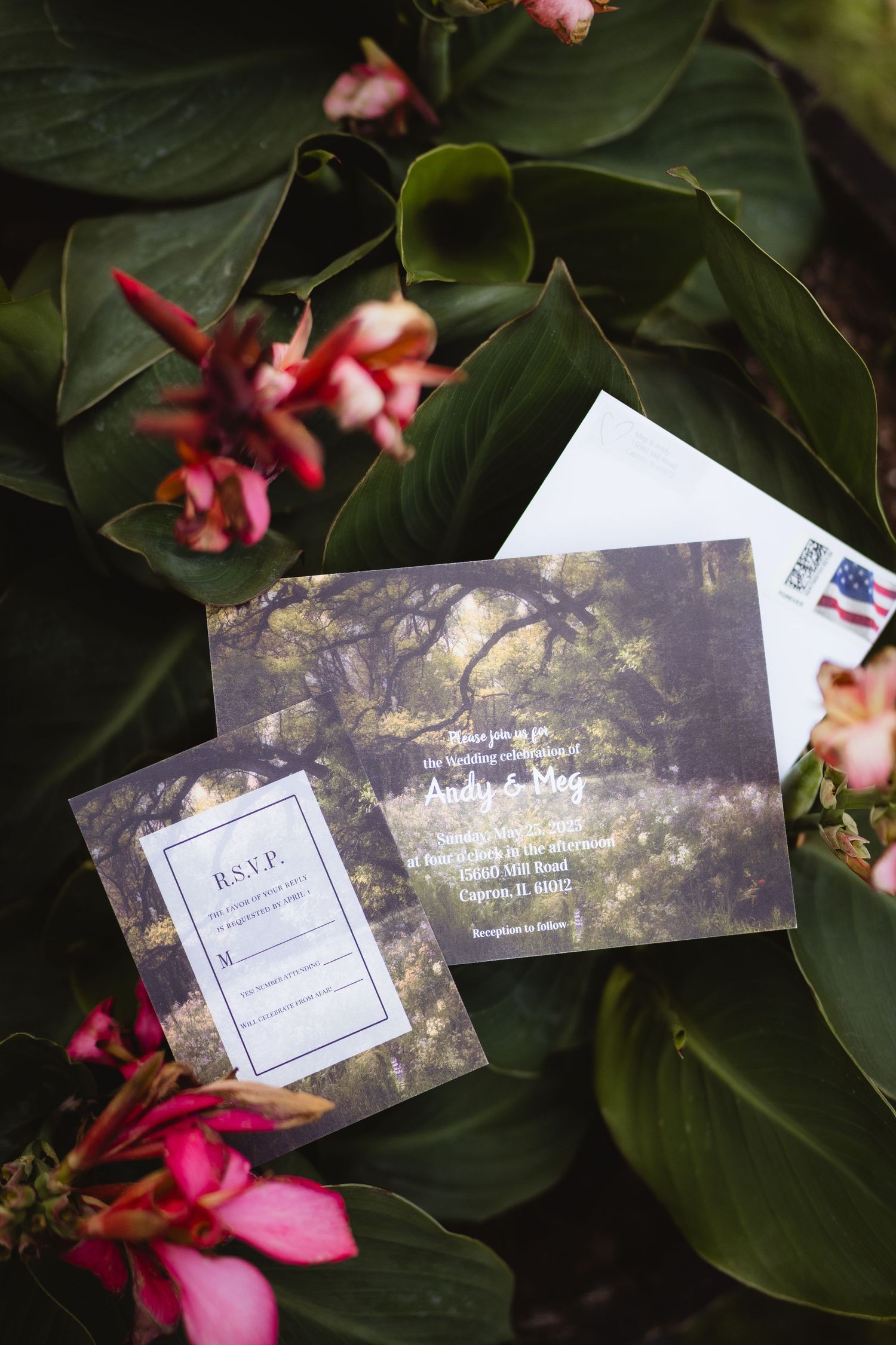 Wedding invitation cards with RSVP resting on green leaves with pink tropical flowers in the background.